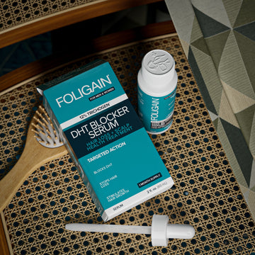 มุมมองจากด้านบนของกล่อง ขวด และหลอดหยดเซรั่ม DHT FOLIGAIN ข้างแปรงผม.