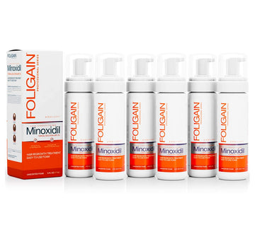 กระป๋องโฟมไมน็อกซิดิล 5% FOLIGAIN ชนิดทาสำหรับผู้ชาย เรียงอยู่ข้างกล่อง.