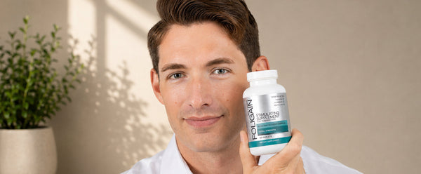 ผู้ชายถือผลิตภัณฑ์เสริมอาหารสูตรกระตุ้น FOLIGAIN สำหรับผมบาง 120 แคปเล็ต.